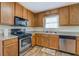 Efficient kitchen layout with stainless steel appliances and wooden cabinetry at 5687 Highway 212, Covington, GA 30016