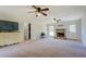 Open-concept living room with a fireplace, neutral walls, plush carpeting, and bright natural light at 5687 Highway 212, Covington, GA 30016