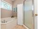 Bathroom featuring a soaking tub, glass-enclosed shower, and a stained-glass window for added character at 1026 Lester Se Ave, Atlanta, GA 30316