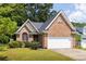 Charming brick home showcasing a well-manicured lawn and a two-car garage at 1026 Lester Se Ave, Atlanta, GA 30316