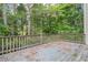 Spacious outdoor back deck with weathered blue paint and a wooden railing, overlooking a large wooded area at 425 Fieldstone Lndg, Alpharetta, GA 30005