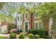 Traditional brick home featuring an attached garage and beautifully landscaped front yard, complemented by a classic arched doorway at 425 Fieldstone Lndg, Alpharetta, GA 30005