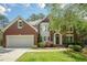 Charming brick two-story home featuring a well-manicured lawn, attached garage, and a classic arched entryway at 425 Fieldstone Lndg, Alpharetta, GA 30005