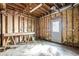 Exposed garage features stud framing, ready for customization, with a workbench and exterior door at 425 Fieldstone Lndg, Alpharetta, GA 30005