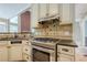 Gas range and oven in the kitchen with custom cabinets and tile backsplash at 425 Fieldstone Lndg, Alpharetta, GA 30005