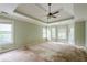 Spacious main bedroom boasts tray ceilings, a ceiling fan, multiple windows, and is awaiting your personal touch at 425 Fieldstone Lndg, Alpharetta, GA 30005