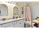 Bathroom featuring double sinks, white cabinets, and decorative floral shower curtain at 5105 Riverthur Pl, Duluth, GA 30096