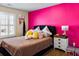Bright bedroom featuring a vibrant pink accent wall and cozy decor at 5105 Riverthur Pl, Duluth, GA 30096