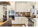 Well-appointed kitchen with stainless steel appliances, granite counters, and custom white cabinets at 5105 Riverthur Pl, Duluth, GA 30096