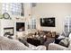 Living room with a cozy fireplace, mounted TV, and light-filled windows with plantation shutters at 5105 Riverthur Pl, Duluth, GA 30096