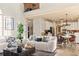 Bright, open-concept living room flows into a modern kitchen, accentuated by a cozy couch and natural light at 5105 Riverthur Pl, Duluth, GA 30096
