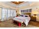 Spacious main bedroom with tray ceilings, large windows, a decorative headboard, and an inviting bench at 5105 Riverthur Pl, Duluth, GA 30096