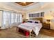 Main bedroom with tray ceiling, large window, bench seating, and a decorative headboard at 5105 Riverthur Pl, Duluth, GA 30096