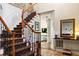 Elegant foyer showcasing a staircase with wood and wrought iron banister and tiled floors at 5105 Riverthur Pl, Duluth, GA 30096