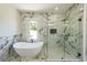 Modern bathroom with marble accents features a freestanding tub and glass-enclosed shower, creating a spa-like experience at 972 Auburn Rd, Dacula, GA 30019