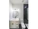 Modern bathroom with white cabinets, a dark tiled shower and a view of the mirror at 972 Auburn Rd, Dacula, GA 30019