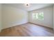 Bedroom with wood floors, a minimalist design, and a large window offering abundant natural light at 972 Auburn Rd, Dacula, GA 30019