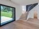 Bright living room with a modern staircase and large glass doors to the outdoor space at 972 Auburn Rd, Dacula, GA 30019