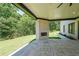 Covered patio features a stone fireplace and peaceful backyard view at 972 Auburn Rd, Dacula, GA 30019