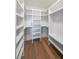 Spacious walk-in closet with custom white shelving and hardwood floors, offering ample storage space at 972 Auburn Rd, Dacula, GA 30019