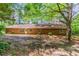 Backyard featuring brick home exterior, patio, and beautiful tall trees at 1296 Carman Se Ct, Conyers, GA 30013