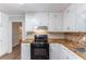 Kitchen with white cabinets, wood countertops and black appliances at 1296 Carman Se Ct, Conyers, GA 30013