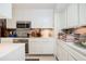 Modern kitchen with white cabinetry, stainless steel appliances, and sleek countertops and mosaic tile backsplash at 145 15Th Ne St # 1225, Atlanta, GA 30309