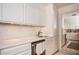 All-white kitchen with stylish mosaic backsplash, stainless steel appliances, and reflective wall mirror at 145 15Th Ne St # 1225, Atlanta, GA 30309