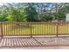 Backyard with a wooden deck and green grass surrounded by mature trees at 7623 Mcgillicuty Dr, Union City, GA 30291