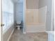 Bathroom featuring a bathtub with tile surround, toilet and tiled floor at 7623 Mcgillicuty Dr, Union City, GA 30291