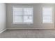 A bright bedroom featuring plush carpeting and two large windows at 7623 Mcgillicuty Dr, Union City, GA 30291