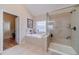 Bright bathroom with a glass shower, bathtub with tile surround, and access to the toilet room at 1657 Williams Mill Way, Dacula, GA 30019