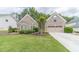 Charming brick home featuring a well-manicured lawn and an attached two-car garage at 1657 Williams Mill Way, Dacula, GA 30019