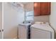 Functional laundry room featuring a modern washer and dryer, overhead shelving, and a bright window at 1657 Williams Mill Way, Dacula, GA 30019