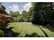 Expansive backyard with lush green lawn, mature trees, and a playset at 1890 Silvastone Dr, Decatur, GA 30033