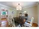 Bright dining room with hardwood floors, elegant gray sideboard, and modern drum light fixture at 1890 Silvastone Dr, Decatur, GA 30033
