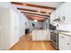 Modern kitchen featuring stainless steel appliances, white cabinets, wood floors, and exposed beams at 1890 Silvastone Dr, Decatur, GA 30033
