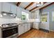 Modern kitchen with white cabinets, stainless appliances, granite countertops, and wood-beam ceiling at 1890 Silvastone Dr, Decatur, GA 30033