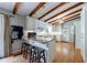Bright kitchen with a breakfast bar, wooden beams, white cabinets, and stainless steel appliances at 1890 Silvastone Dr, Decatur, GA 30033