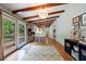 Open living room area with beautiful hardwood floors, wooden beam ceilings, and access to the back yard at 1890 Silvastone Dr, Decatur, GA 30033