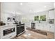 Modern kitchen featuring stainless steel appliances, white cabinetry, an island, and hardwood style flooring at 2376 Cross Nw St, Atlanta, GA 30318