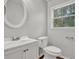 Well-lit bathroom featuring a vanity with a white sink, toilet, and window at 3189 Glen Hollow Dr, Rex, GA 30273