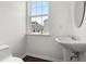Bright powder room featuring pedestal sink, dark wood floors, and a window with a neighborhood view at 6750 Blackstone Pl # 6, Mableton, GA 30126