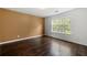 This bedroom features hardwood floors, a window and tan and white paint at 6750 Blackstone Pl # 6, Mableton, GA 30126