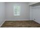 A bright bedroom with a window, new flooring, and neutral paint at 1808 Arkose Se Dr, Atlanta, GA 30316