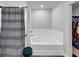 Bathroom showcasing bathtub, tiled walls, a gray shower curtain and a green stool at 201 Kingfisher Walk, Covington, GA 30014