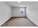 Empty bedroom featuring neutral walls, carpet, and one sunny window at 201 Kingfisher Walk, Covington, GA 30014