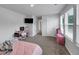 Bedroom featuring desk, TV, pink storage bin, and lots of light from sunny windows at 201 Kingfisher Walk, Covington, GA 30014