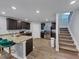 Modern kitchen with granite countertops, stainless steel appliances, and adjacent staircase at 201 Kingfisher Walk, Covington, GA 30014