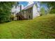 Exterior view of the home with a grassy backyard featuring mature trees at 2430 Harbin Springs Cv, Dacula, GA 30019